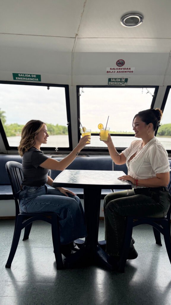 amigas merendando en un catamaran de paseo haciendo un brindis con limonada