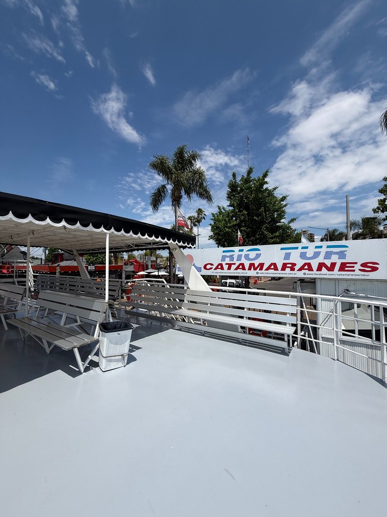 terraza de un catamaran de paseo y al fondo la boleteria de rio tur catamaranes