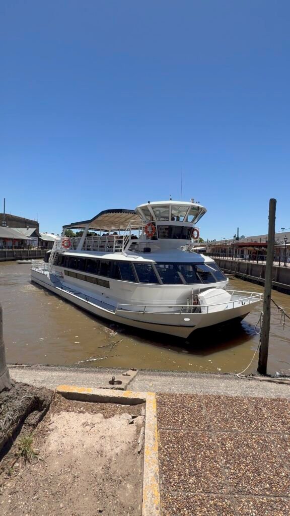 Catamaran de dos pisos saliendo del muelle en el Delta del Tigre