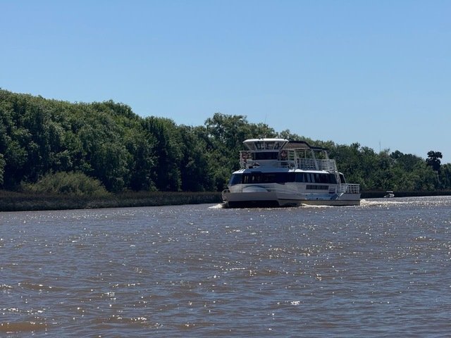 catamaran de frente navegando por un canal en el delta de tigre