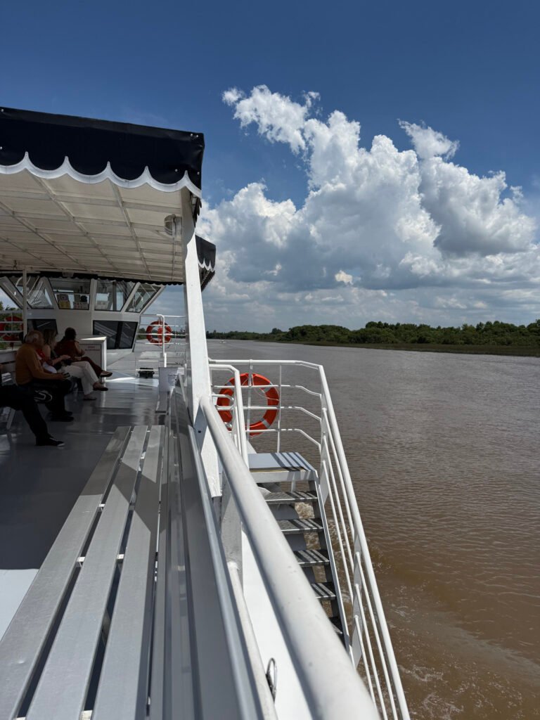 Fotografia tomada desde el borde de un catamaran navegando y un salvavidas colgando de las barandas