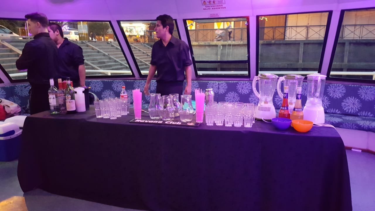 Barra de tragos y dos bartenders en un catamaran